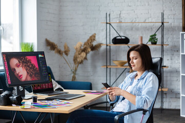 Wall Mural - Portrait of graphic designer working in office with laptop,monitor,graphic drawing tablet and color palette.Retouching images in special program.Retoucher workplace in photo studio.Creative agency.