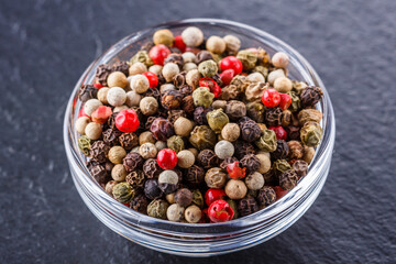 mix of peppercorns on a dark stone background