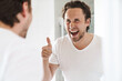 © Drobot Dean - Attractive young man standing in front of the bathroom mirror
