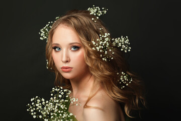 Wall Mural - Portrait of fashion model girl with blonde curly hair and white flowers on head, beautiful face closeup