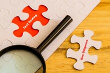 Conceptual Of Due Diligence Fact Finding. Text Due Diligence On Loose Jigsaw Piece. Fact Finding On Red In Place Of Missing Piece. Magnifier On Off-white Jigsaw Puzzle. Selective Focus Wooden Surface.