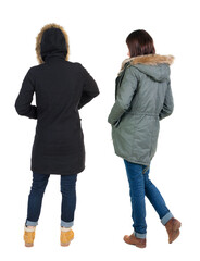 Canvas Print - Back view of two young woman in winter jackets.