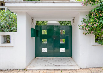 Wall Mural - modern apartment building entrance portico with green painted door by the sidewalk