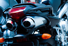 Exhaust Pipes And Brake Light Of A Motorcycle Closeup. The Noise Of A Sports Bike In A Garage. Rear View Of A Classic Road Bike. A Pair Of Chrome Pipes Selective Focus