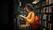 © Gorodenkoff - University Library: Portrait of Gifted Beautiful Black Girl Stands Between Rows of Bookshelves and Searching for the Right Book Title, Finds and Picks one for Class Assignment