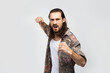 © Marharyta Hanhalo - Assault, dangerous rude guy, bully and bandit crawls into a fist fight. Hipster traveler stylish carefree man on a white studio background, people lifestyle
