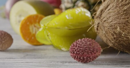 Wall Mural - Close-up dolly slow motion of passion fruit, carambola, litchi on a wooden background. Concept of vegetarian diet eating. Dolly motion, 4K UHD video, 3840, 2160p.