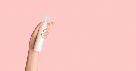 Poster - Unrecognizable young lady holding white sprayer bottle with cosmetic product against pink background, empty space