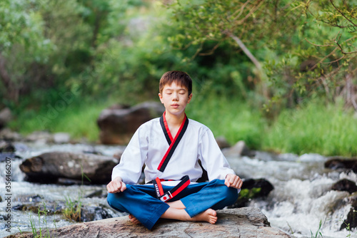 Dekoracja na wymiar  portret-japonskiego-chlopca-taekwondo-siedzacego-na-lonie-natury-i-wykonujacego-cwiczenia-medytacyjne