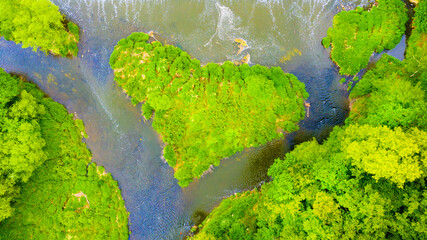 Green heart shaped island on river in Upper Berounka natural park. Wonder of nature near Pilsen. Amazing destination in Czech Republic. Aerial view to European landmark. 