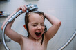 © Cavan Images - Close up of girl washing her hair with shower