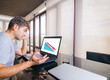 © GENETTICA - Young man worried in front of laptop with bad economic results on the screen