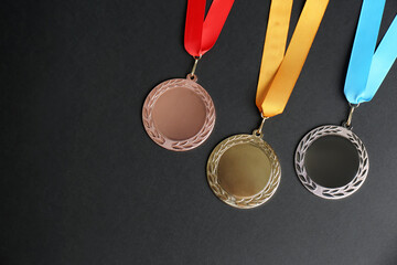 Gold, silver and bronze medals on black background, flat lay. Space for design