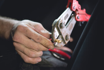 Wall Mural - Auto electrician crimps wire terminals of car audio close up.