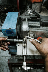 Wall Mural - Close up shot of manual worker hands. Factory for industrial production of hydraulic hoses.