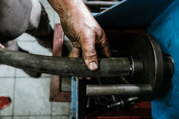 Wall Mural - Close up shot of manual worker hands. Factory for industrial production of hydraulic hoses.