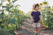 © David Cabrera/ADDICTIVE STOCK - Cheerful little boy in casual clothes and hat standing in green sunflowers field