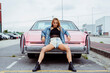 © Manuel Ruiz Alba/ADDICTIVE STOCK - Sensual blonde girl sitting on the bumper of a classic pink car looking at the camera