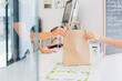 © Manuel Ruiz Alba/ADDICTIVE STOCK - Side view of anonymous restaurant staff passing paper bag with ordered food to crop customer behind the counter