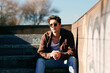 © Manuel Ruiz Alba/ADDICTIVE STOCK - Young handsome guy in casual clothes looking at camera while sitting on stairs on sunny day on city street