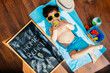 © Nehomar Hernandez/ADDICTIVE STOCK - From above view of cheerful little boy in yellow sunglasses and blue swimwear eating apple while lying on towel on floor having home beach on quarantine