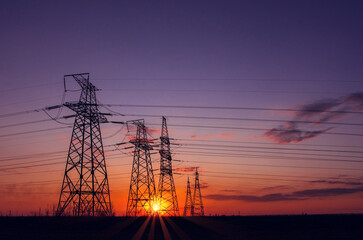  high-voltage  power lines at sunset.