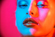 © de Art - Fashion model metallic silver lips and face woman in neon uv blue and purple lights, posing in studio, beautiful girl, glowing make-up, colorful make up.