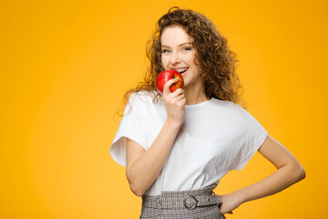 Wall Mural - Pretty girl with curly hair holding fresh apple