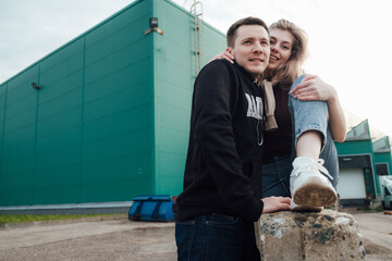 young fashionable in love beautiful couple shopping and having fun near the supermarket ride on a trolley