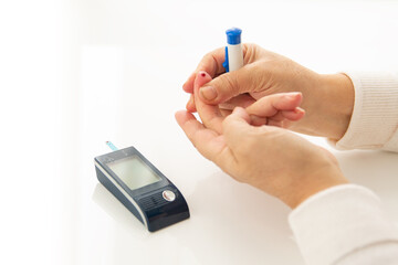 hand pressing on finger for blood to drain needed for sugar level test