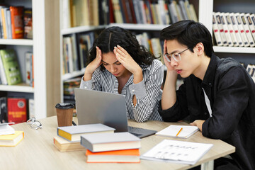 Wall Mural - Stressed students preparing for examination in library