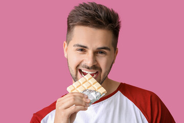 Sticker - Handsome young man with tasty chocolate on color background