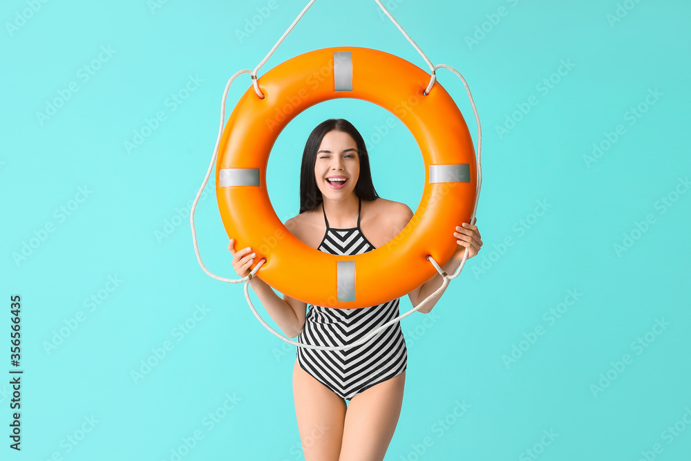Beach rescuer with lifebuoy on color background