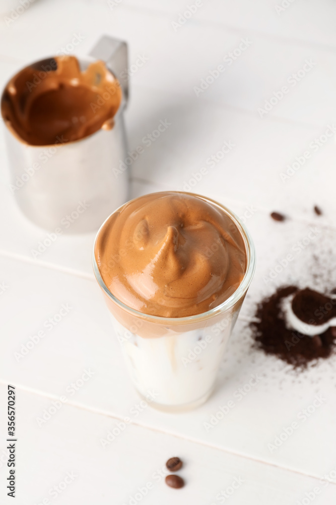 Glass of tasty dalgona coffee on table