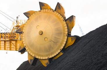 Coal mining rotating buckets sorting and moving the coal into stacks, on a isolated white background with copy space.