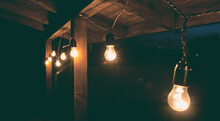 The Garland Of  Light Bulbs Hanging On The Wooden Terrace