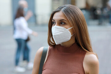 Wall Mural - Young elegant woman in city street wearing KN95 FFP2 protective mask