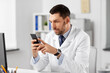 © Syda Productions - healthcare, medicine and people concept - male doctor with smartphone at hospital