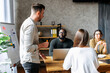 © Vadim Pastuh - Brainstorm at the morning meeting. A young, successful multiracial team of startupers discuss business challenges while sitting at a table in a contemporary office space
