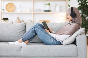 Wall Mural - Favorite Passtime. Smiling Muslim Woman Relaxing With Digital Tablet At Home