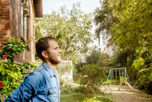 Uomo Con Camicia In Jean è Rilassato Nel Giardino Di Casa Sua
