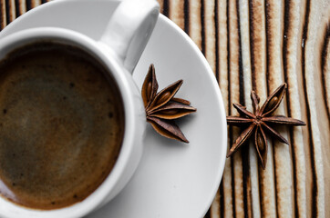 espresso on wooden background with star anise and cinnamon