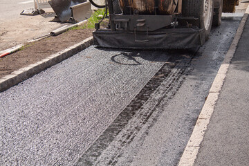 Street resurfacing with fresh asphalt construction.