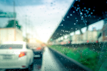 Rain drops on windshield. Car driving on asphalt road on rainy day. Windshield window of car with raindrops on glass windscreen. Traffic jam on rainy season. Bad weather in stormy day. Travel by car.