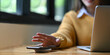 © Prathankarnpap - Cropped image of an office woman is charging a smartphone with a wireless charger while typing on a computer laptop.