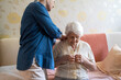 © pikselstock - Woman helping senior woman dress in her bedroom