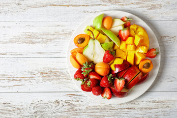 Wall Mural - Fruit platter of mango, apple, apricot, copy space