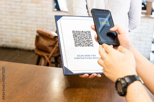 Fotografía Person scanning contactless menu QR code with smartphone as new normal