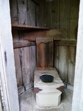 Abandoned Wooden Outhouse With Wooden Toilet Seat