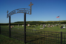 A Sign On A Fence Around A Country Cemetery